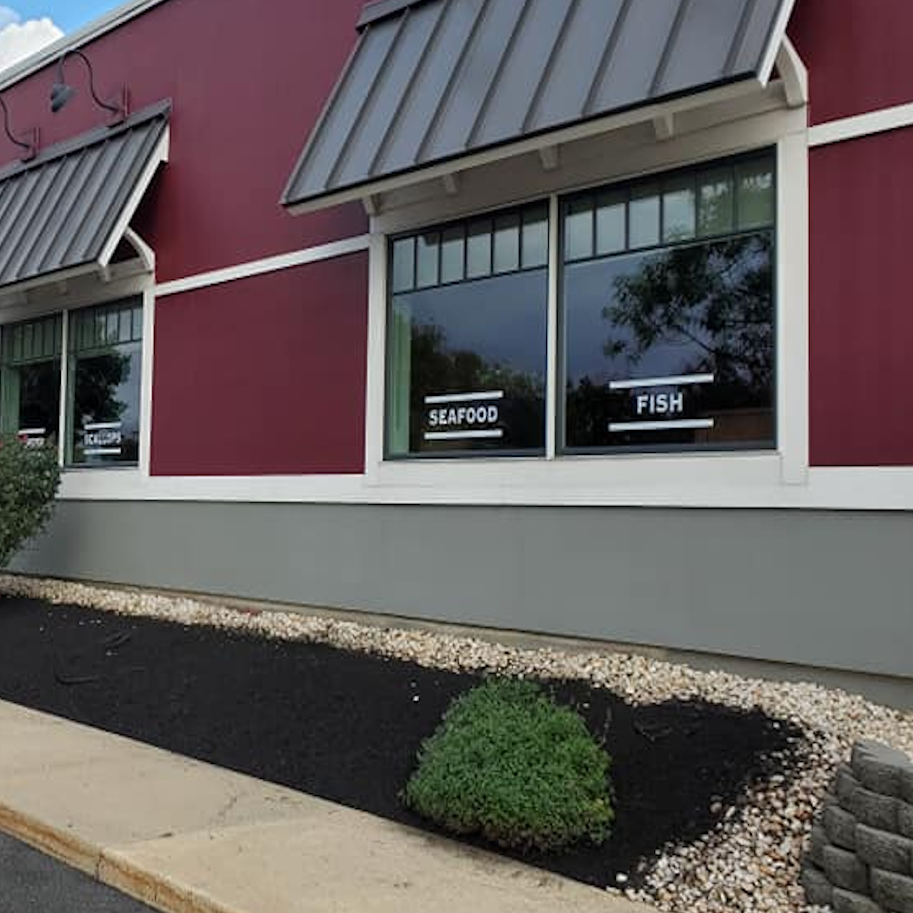 Commercial property landscaping maintenance by Fox Landscaping featuring clean landscape stone edging, dark mulch beds, and manicured shrubs outside a local restaurant storefront. Commercial property landscaping maintenance by Fox Landscaping featuring clean landscape stone edging, dark mulch beds, and manicured shrubs outside a local restaurant storefront.