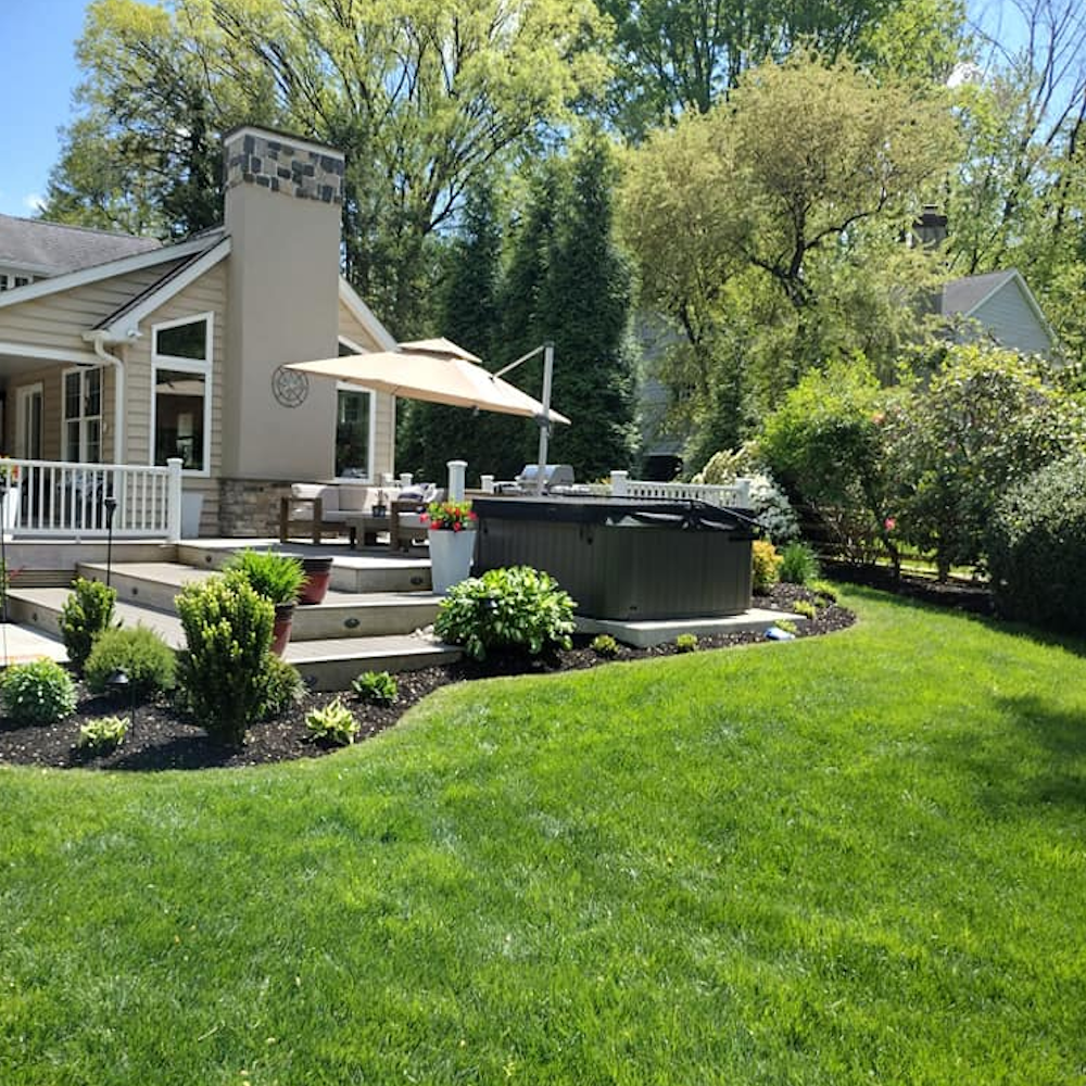 Backyard transformation by Fox Landscaping featuring professional lawn care, curved landscape edging with black mulch, and a multi-level deck and hot tub surround. Backyard transformation by Fox Landscaping featuring professional lawn care, curved landscape edging with black mulch, and a multi-level deck and hot tub surround.